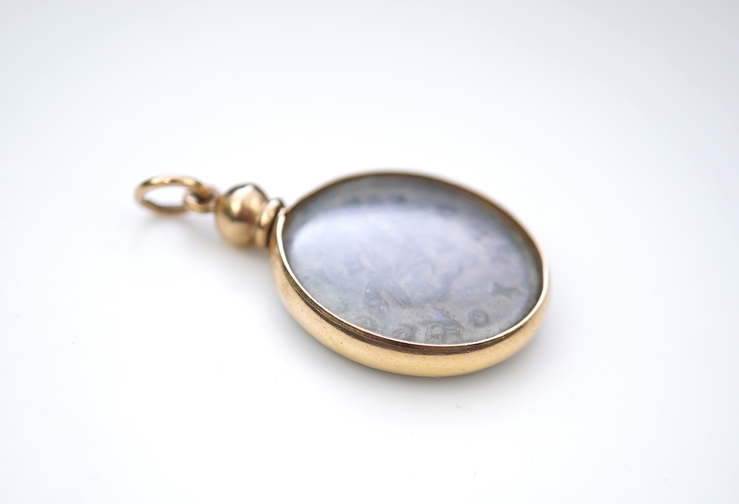 A gold and Roman bronze coin pendant
